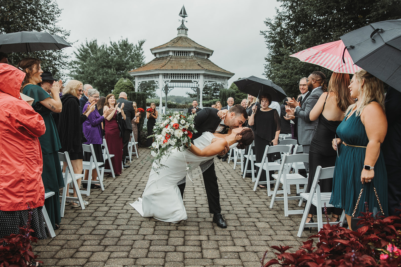 Bride and Groom Kiss Leaving Rainy Wedding Ceremony